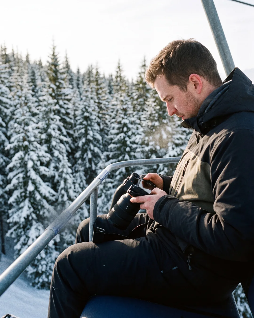 Photographer on a chairlift checking images