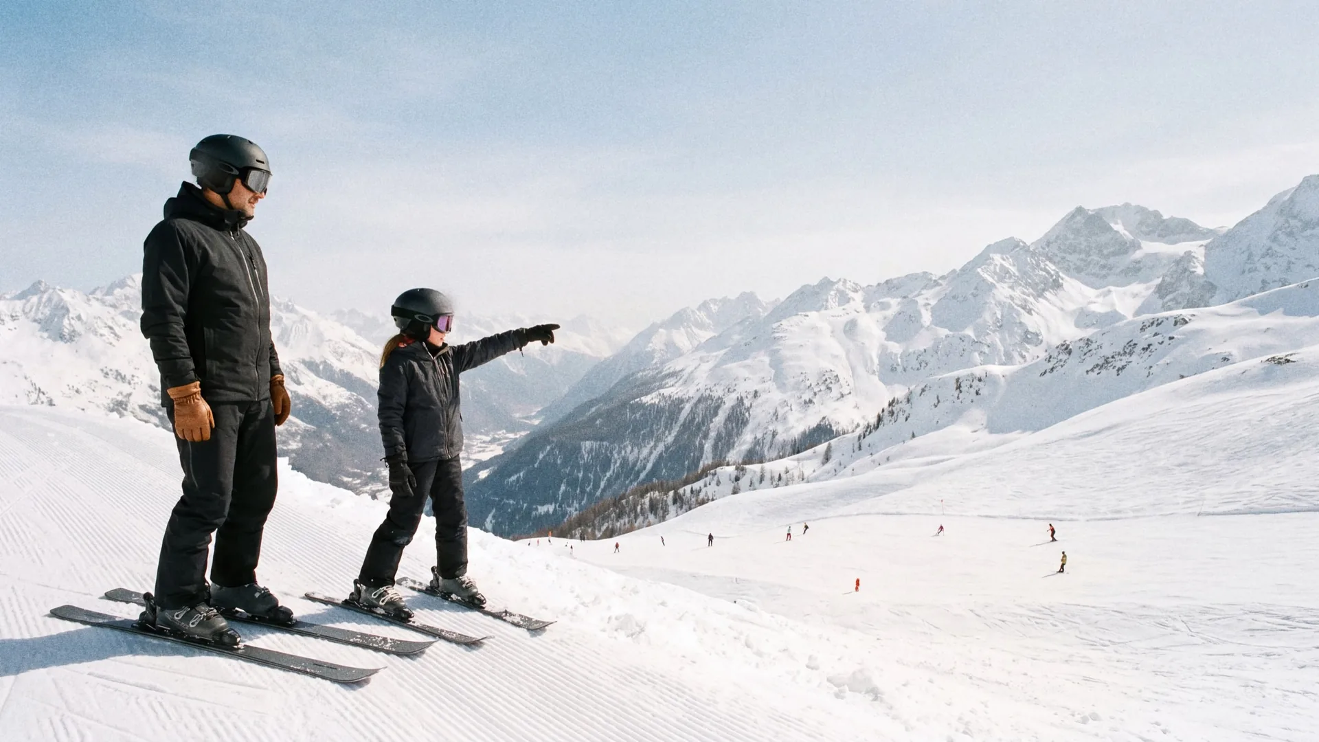 A photographer on skis photographing a couple on a groomed slope above Courchevel 1850 in late afternoon winter light.